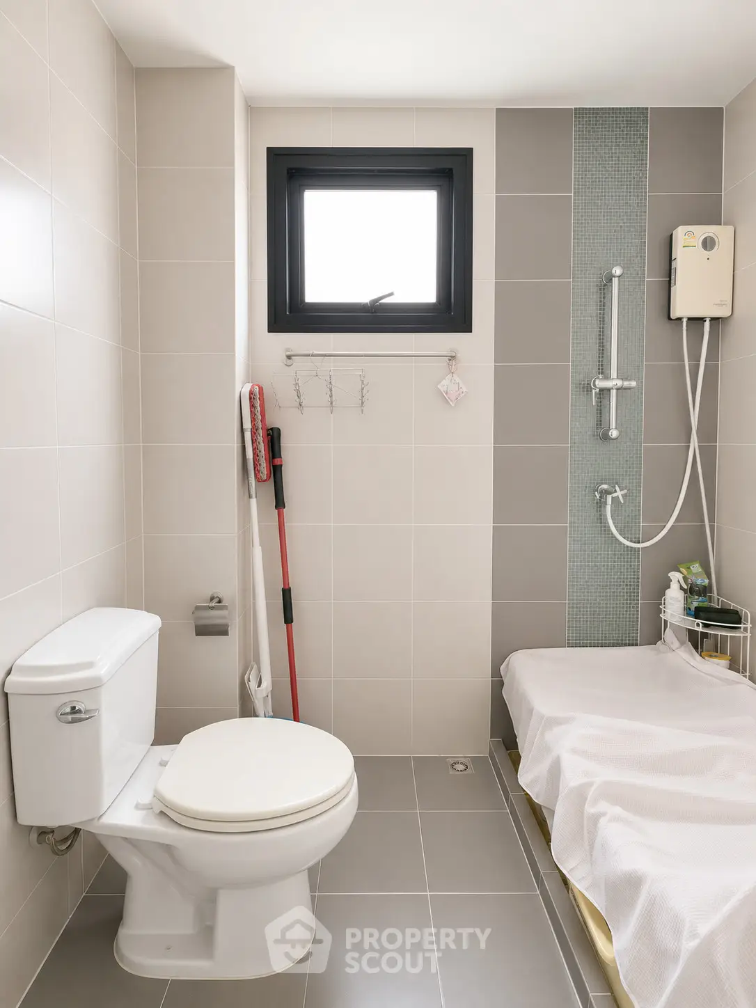 Modern bathroom with sleek design, featuring a shower, toilet, and window for natural light.