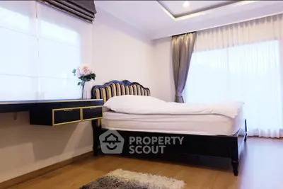 Elegant bedroom with stylish bed and natural light, featuring modern decor and cozy ambiance.