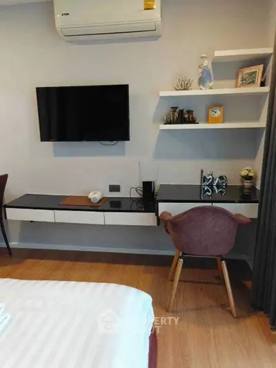 Modern bedroom with wall-mounted TV, air conditioning, and stylish decor