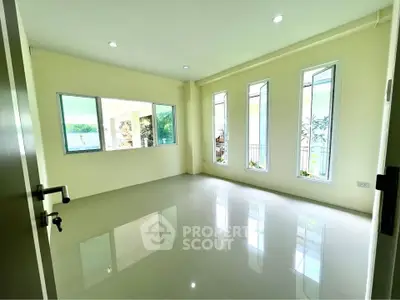 Bright empty room with large windows and glossy tiled floor, perfect for customization.