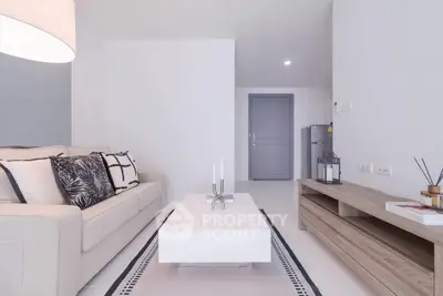 Modern living room with stylish decor and neutral tones, featuring a cozy sofa and sleek coffee table.