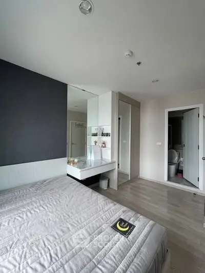 Modern bedroom with sleek design and ensuite bathroom, featuring a stylish vanity and ample storage.