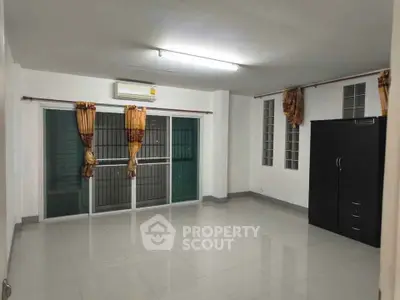 Spacious unfurnished room with large windows and air conditioning, perfect for customization.