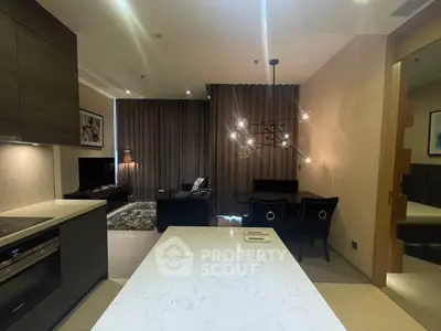 Modern open-layout kitchen and living room with stylish lighting and dark curtains.