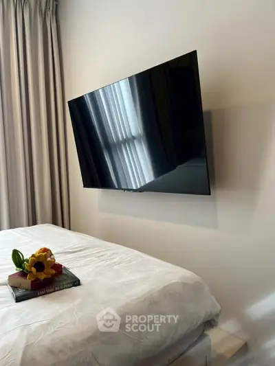 Modern bedroom with wall-mounted TV and elegant decor