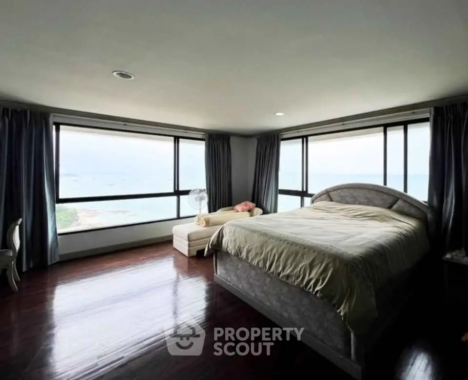 Spacious bedroom with panoramic ocean view and elegant furnishings.
