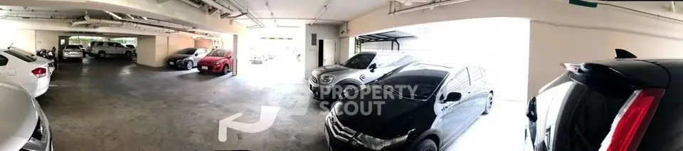 Spacious indoor parking area with multiple vehicles in a well-lit garage.