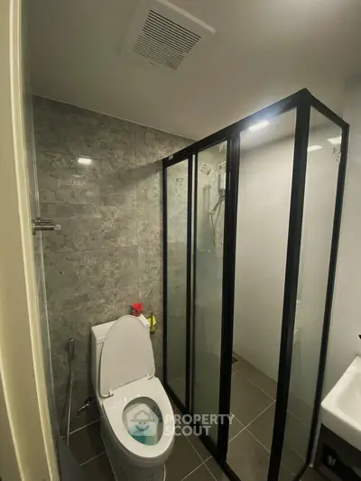 Modern bathroom with glass shower enclosure and sleek tile design.
