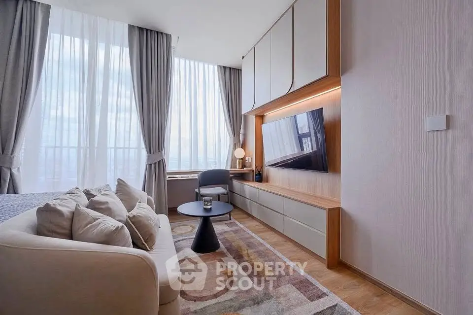 Modern living room with large windows, cozy sofa, and stylish decor