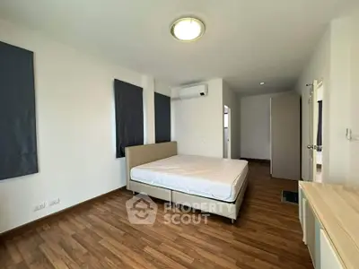 Spacious bedroom with wooden flooring and modern design