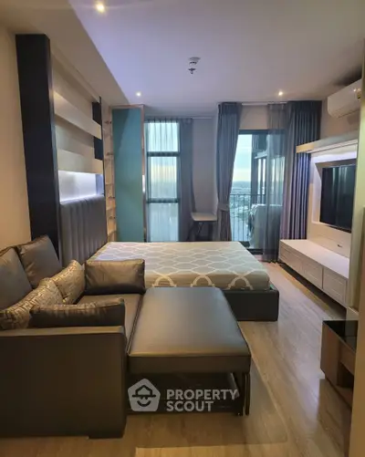 Modern studio apartment with stylish decor and large windows offering a stunning city view.