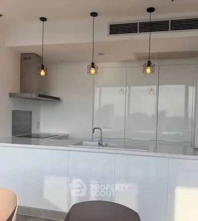 Modern kitchen with sleek white cabinetry and stylish pendant lighting