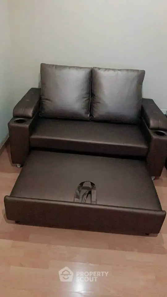 Compact brown sofa bed in a cozy living room setting, perfect for small spaces.