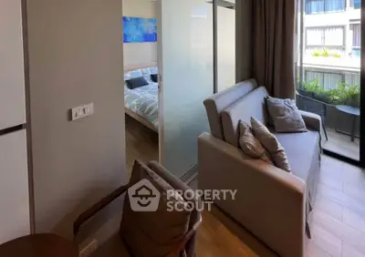 Modern apartment with cozy living room and bedroom, featuring a balcony with outdoor seating.