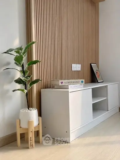 Modern living room corner with stylish wooden paneling and minimalist decor