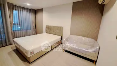 Spacious bedroom with modern decor and large window for natural light.