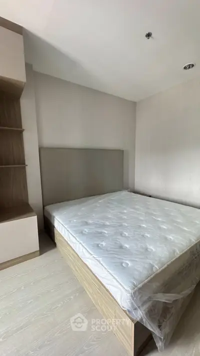 Modern bedroom with minimalist design and built-in storage, featuring a comfortable bed and neutral tones.