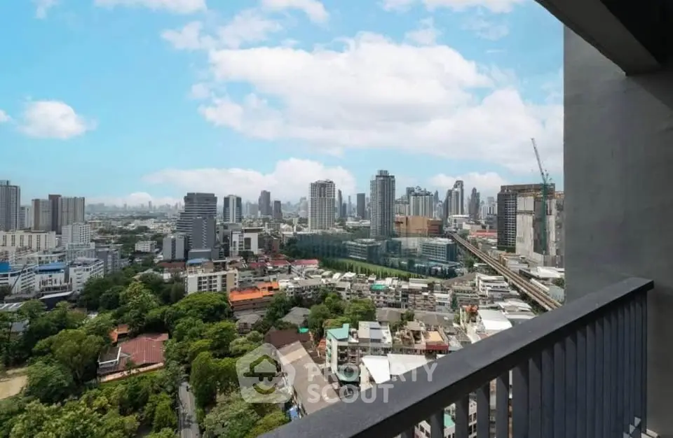 Stunning cityscape view from a high-rise balcony overlooking urban skyline and lush greenery.