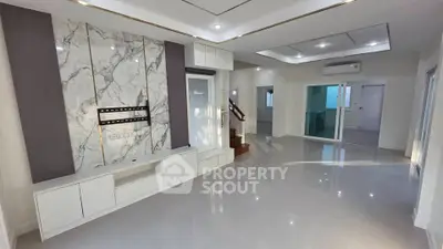 Spacious modern living room with marble accent wall and sleek white cabinetry