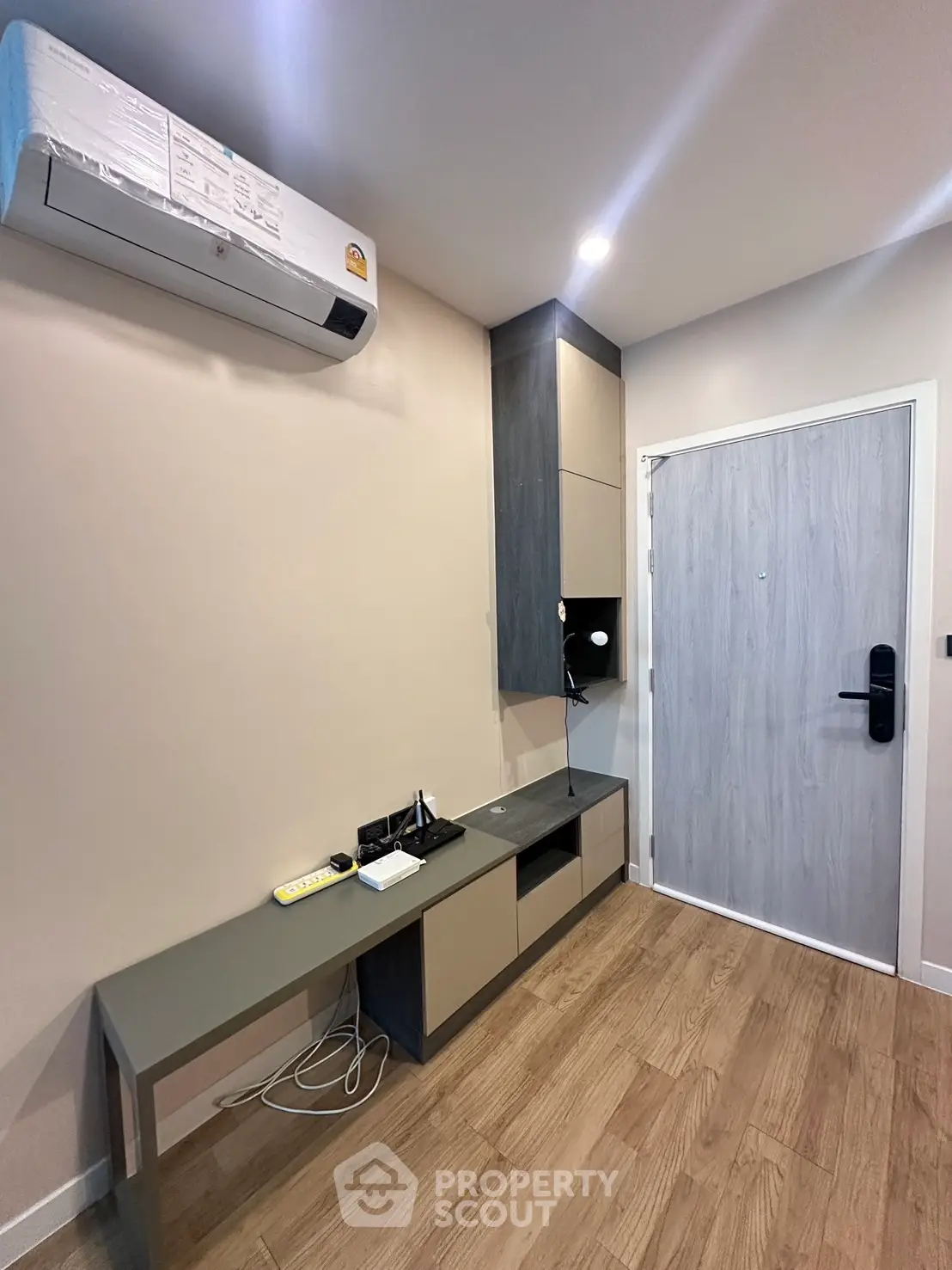 Modern apartment entrance with sleek storage and air conditioning