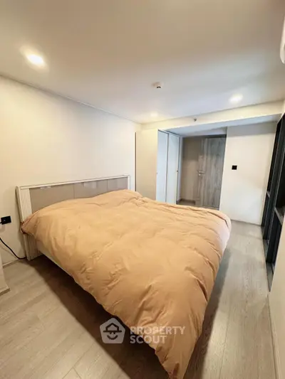Spacious bedroom with modern design and cozy ambiance, featuring a large bed and ample natural light.