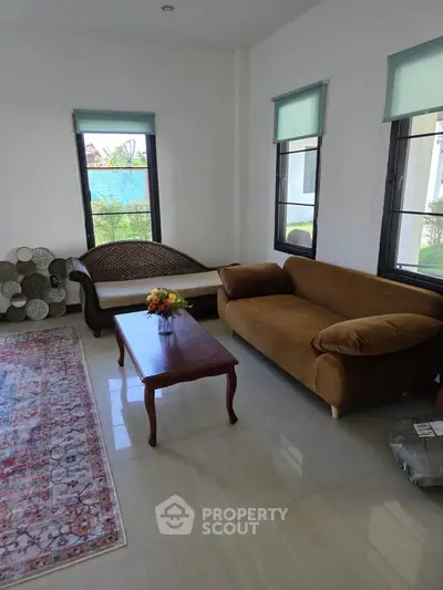 Spacious living room with elegant furniture and large windows offering natural light.