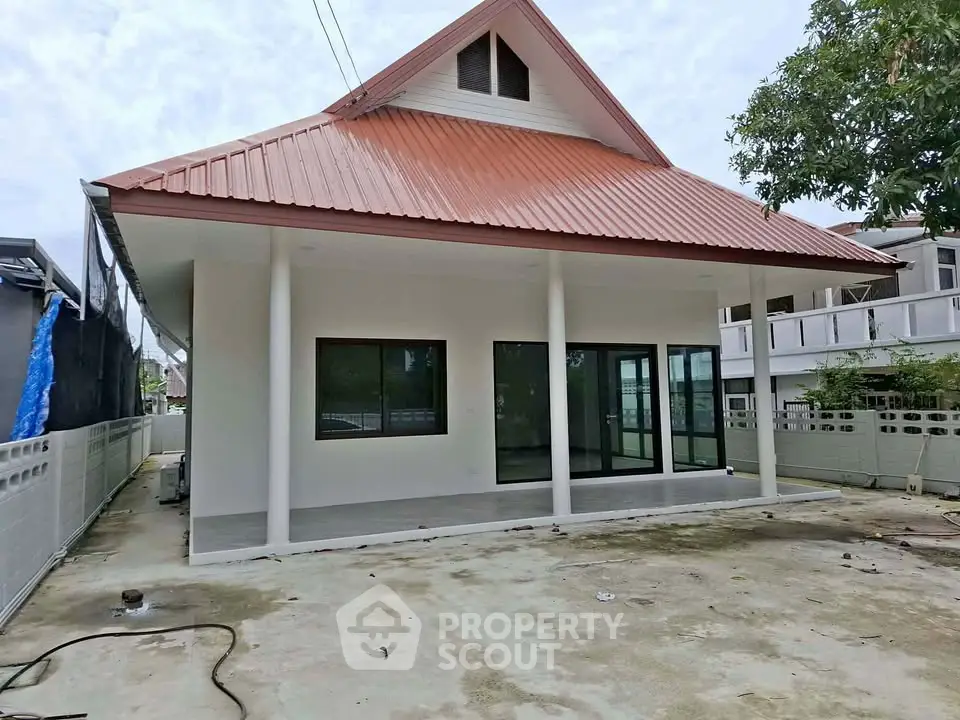Charming single-story house with red roof and spacious patio, perfect for family living.