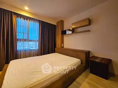 Spacious bedroom with modern design and large window offering city views.