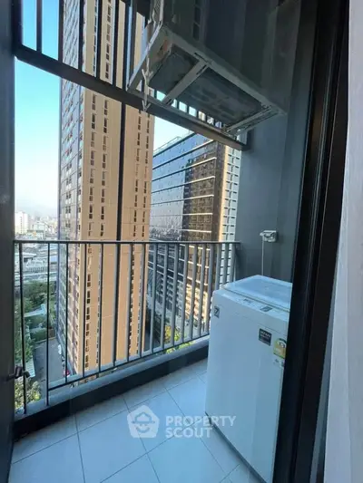 Modern high-rise balcony with city view and washing machine setup.