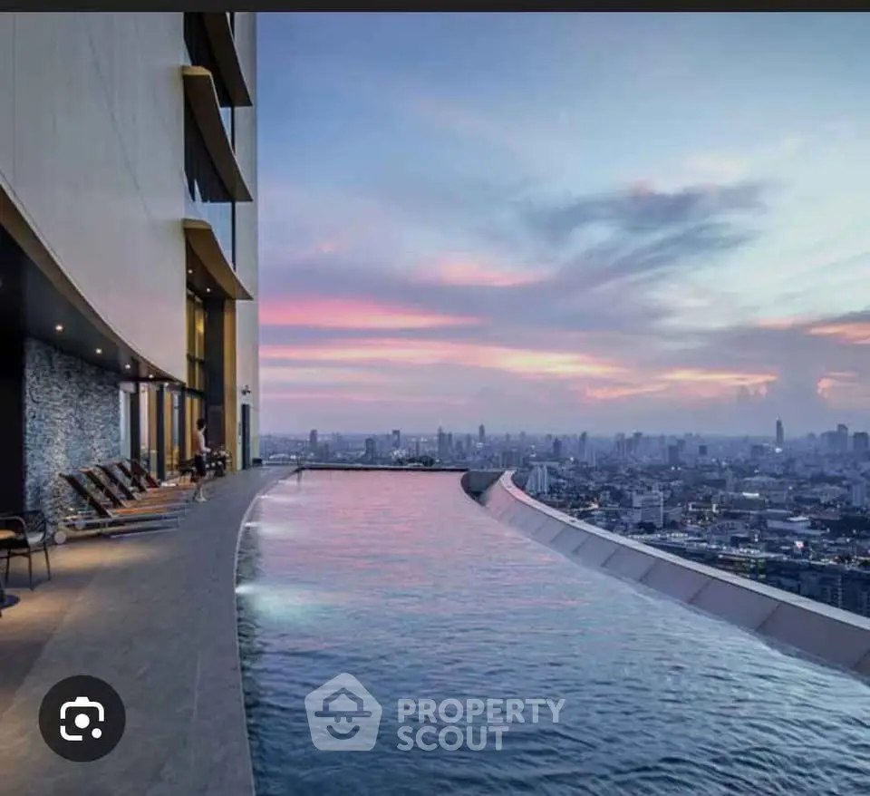 Stunning rooftop infinity pool with breathtaking city skyline view at sunset.