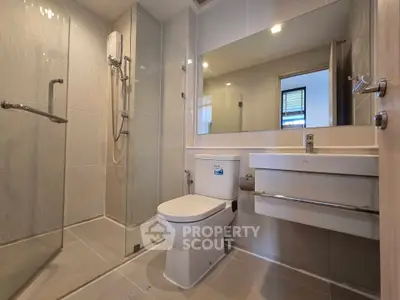 Modern bathroom with glass shower and sleek fixtures in a contemporary apartment.