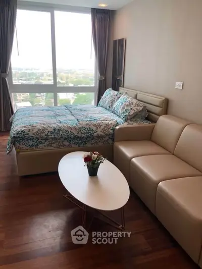 Cozy bedroom with large window and stylish decor, perfect for relaxation.