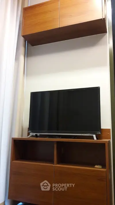 Modern living room with sleek wooden TV cabinet and wall-mounted storage