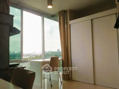 Bright modern interior with large windows and city view, featuring sleek furniture and ample natural light.