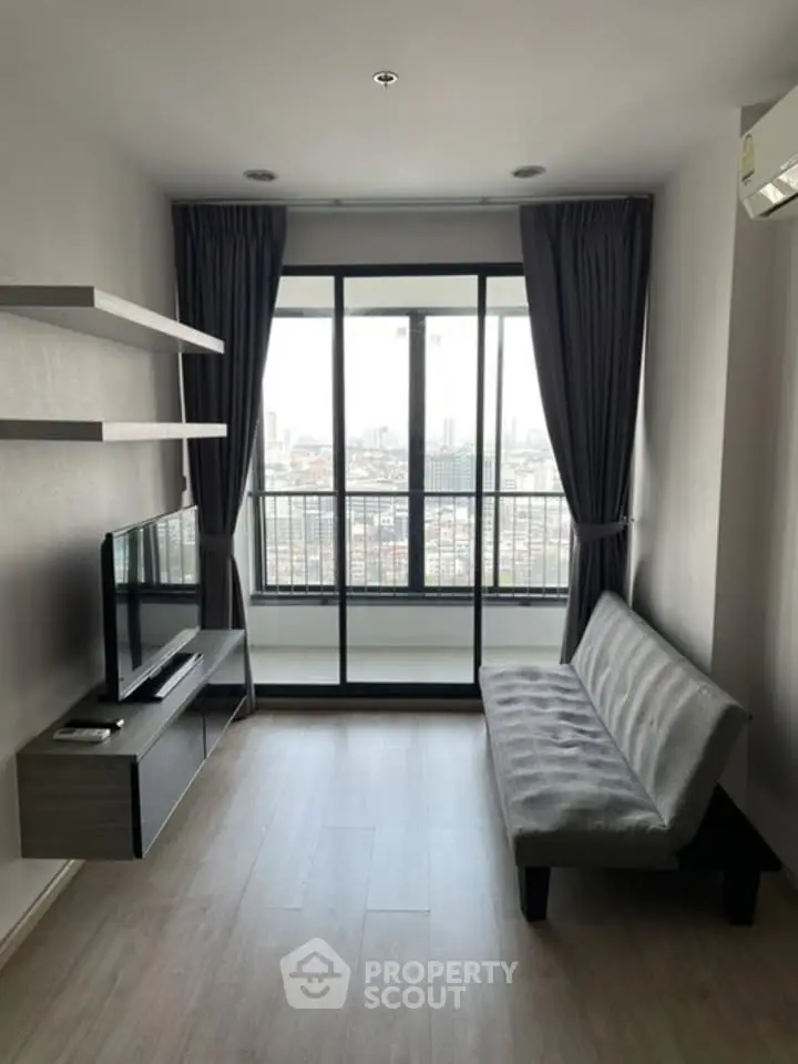 Modern living room with city view, sleek furniture, and large windows for natural light.