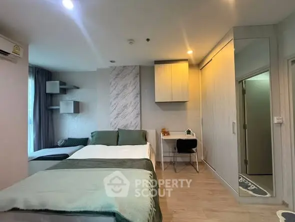 Modern bedroom with cozy decor and study area, featuring stylish lighting and ample storage.