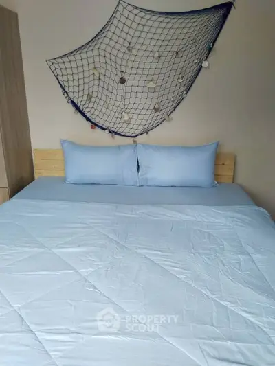 Cozy bedroom with nautical decor and soft blue bedding, perfect for relaxation.