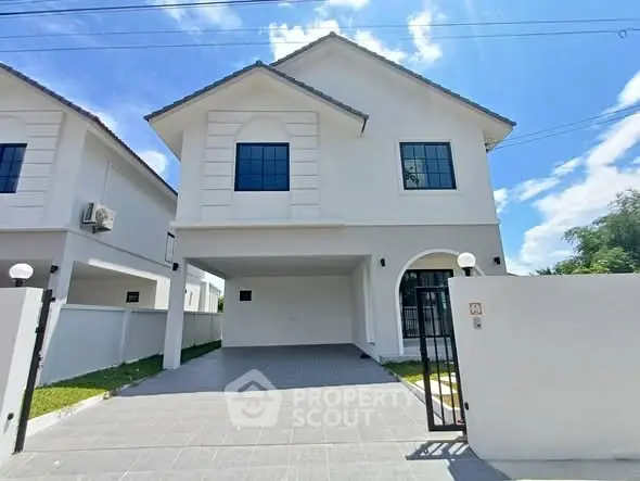 Modern two-story house with spacious driveway and elegant facade under clear blue sky.