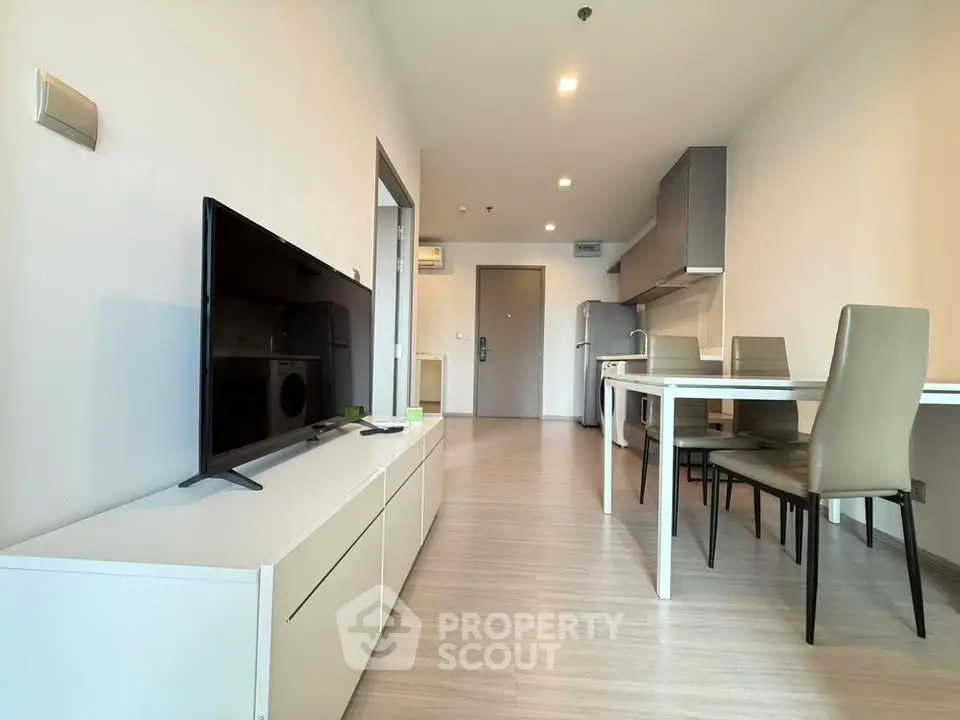 Modern open-plan living room and kitchen with sleek furniture and neutral tones.