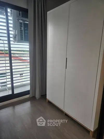 Modern apartment with sleek wardrobe and balcony view, perfect for urban living.