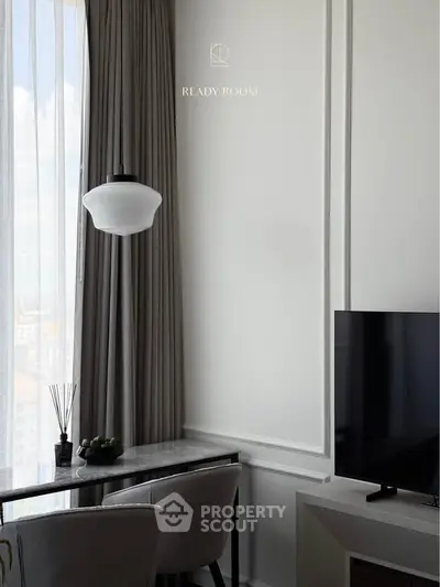 Elegant living room with modern decor, featuring a sleek TV and stylish dining area by a large window.