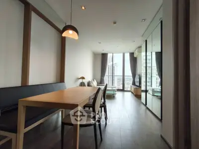 Modern living room with city view, sleek furniture, and floor-to-ceiling windows in urban apartment.