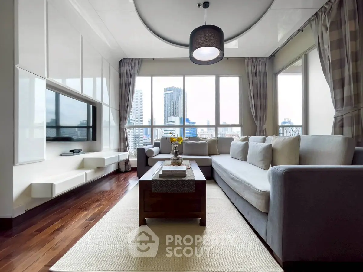 Spacious modern living room with city view, featuring elegant decor and ample natural light.