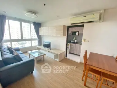 Modern living room with large window and open kitchen layout in urban apartment.