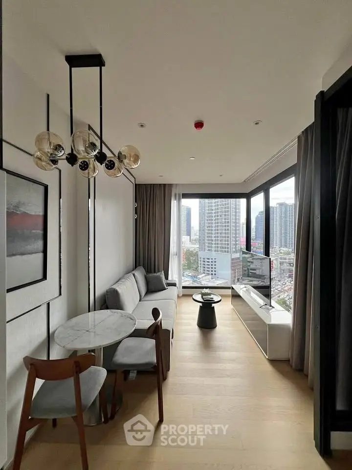 Modern living room with city view, stylish furniture, and floor-to-ceiling windows in a high-rise apartment.