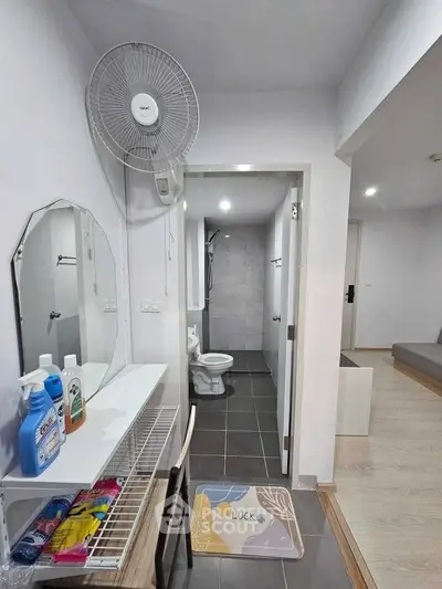 Compact bathroom with modern fixtures and adjacent storage area in a cozy apartment.