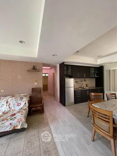 Spacious open-layout living room with modern kitchen and dining area, featuring stylish furniture and ample natural light.
