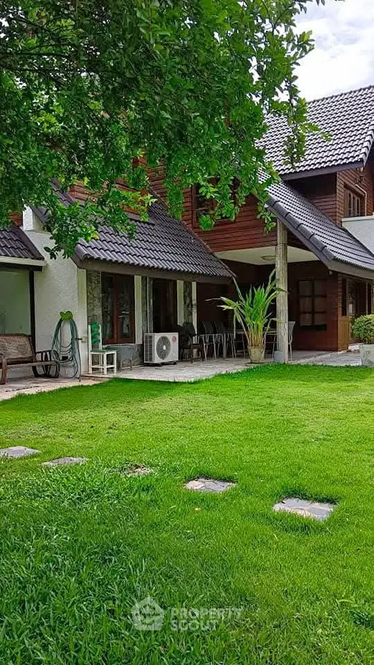 Charming suburban home with lush green lawn and cozy patio area, perfect for family gatherings.