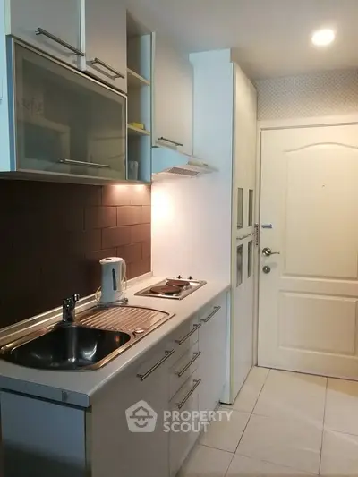 Modern compact kitchen with sleek cabinetry and built-in appliances