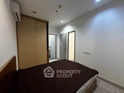 Cozy bedroom with modern design, featuring a comfortable bed and built-in wardrobe.